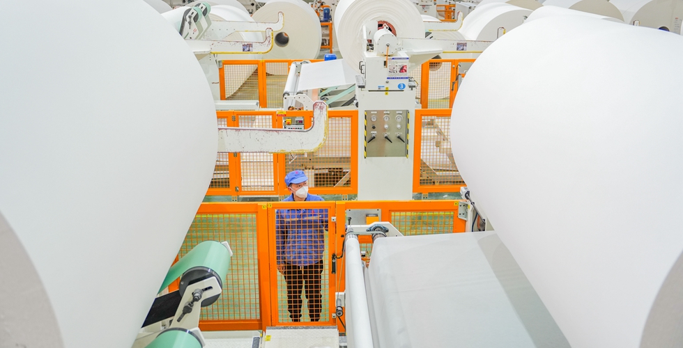 重庆数智产业园恒安纸业有限公司生产车间，工人在操控设备生产。