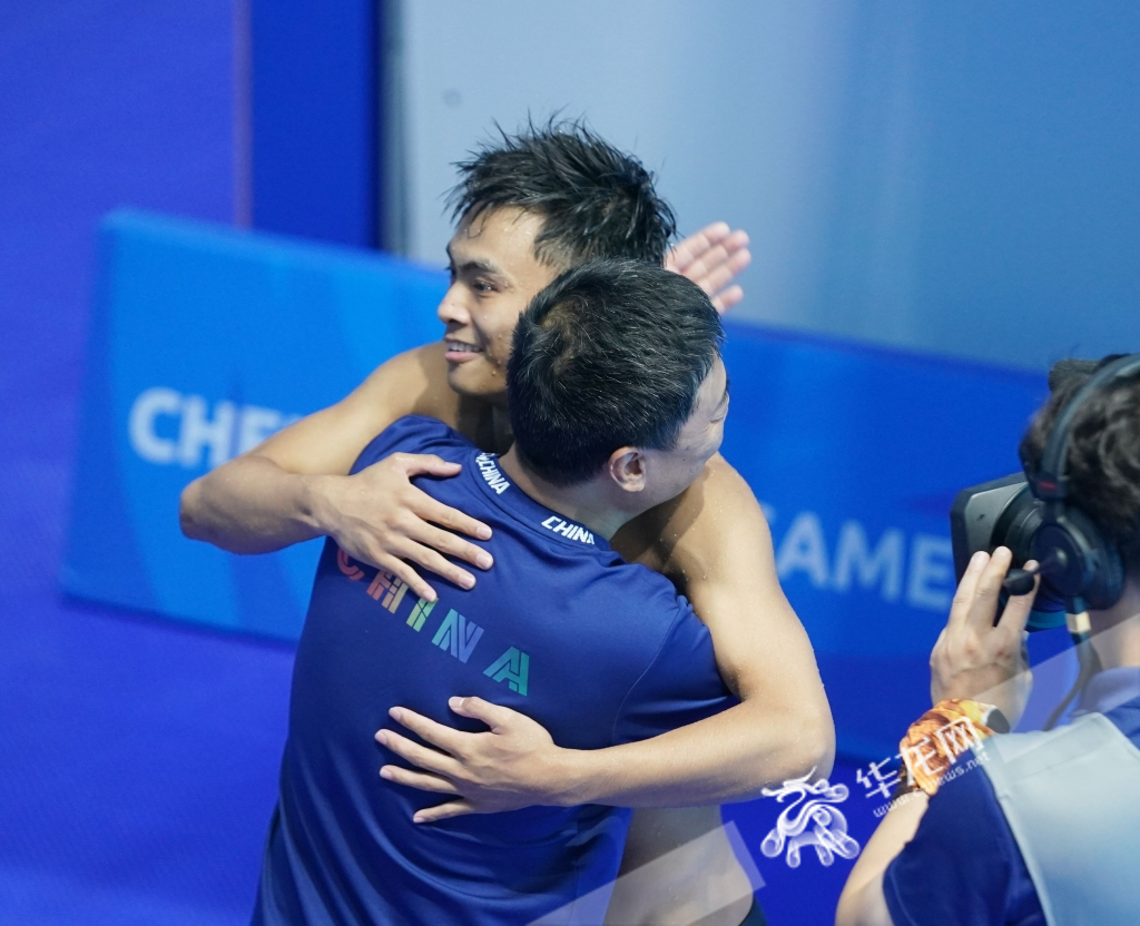After finishing the final dive, Zhang Wen’ao hugs his coach.