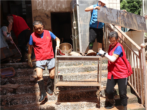 志愿者在清理灾后现场。潼南区委宣传部供图  华龙网发