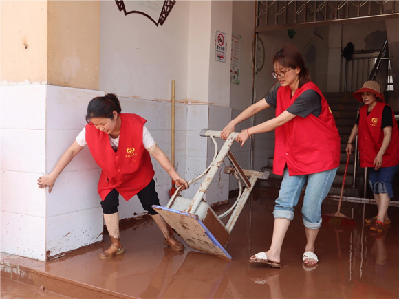 志愿者在灾后现场清理物品。潼南区委宣传部供图  华龙网发