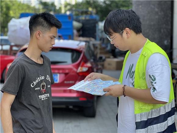 社区志愿者正在向居民发放文明宣传资料。通讯员 陈天红 摄