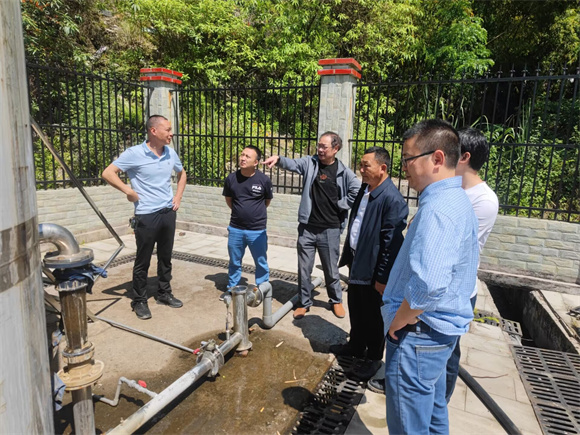 桑崇刚（右一）和团队在九龙山镇进行人饮工程指导。受访者供图