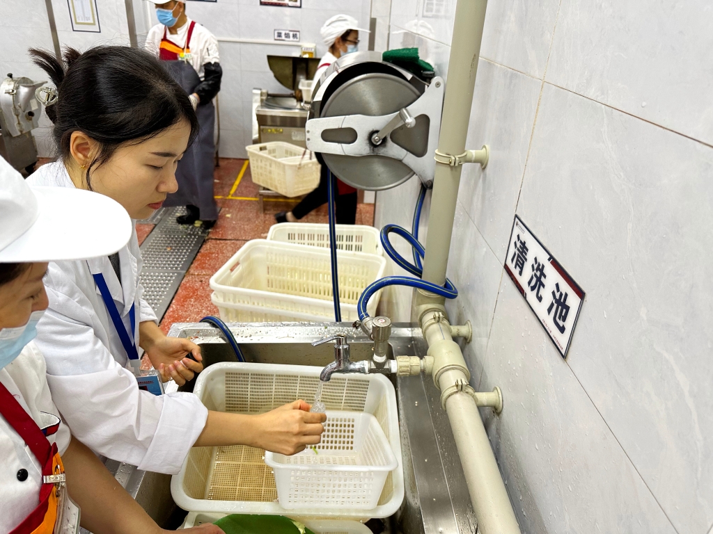 北碚朝阳中学食堂，市自来水公司北碚水厂化验员正在对水进行现场取样检测。重庆水务集团供图