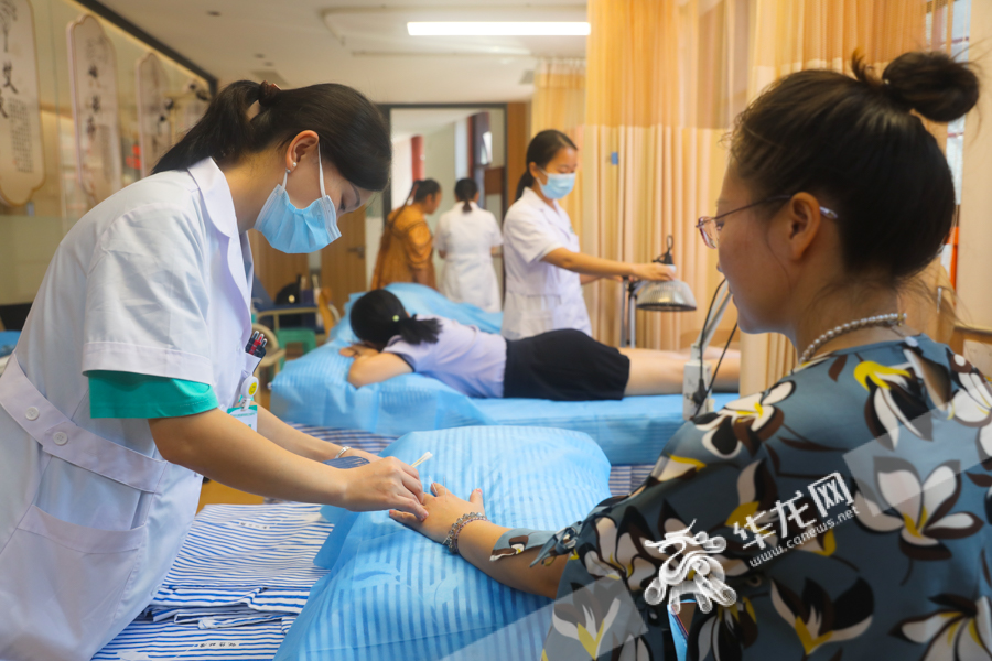 居民们在民主村社区健康管理中心里享受中医理疗服务。华龙网-新重庆客户端记者 张质 摄