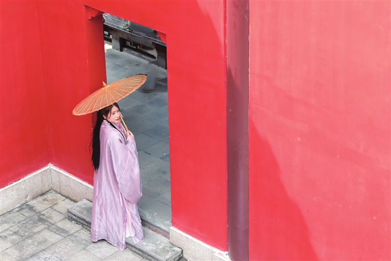 鸿恩寺公园绿瓦红墙，吸引大量市民身着汉服拍照打卡。