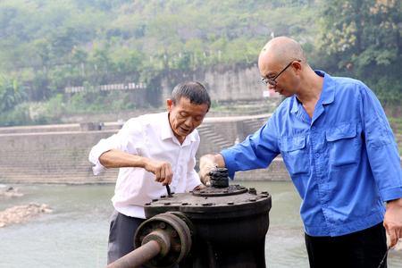 杨仁明（左一）教李国春学习如何使用和维修机器。记者 张梦寒 摄