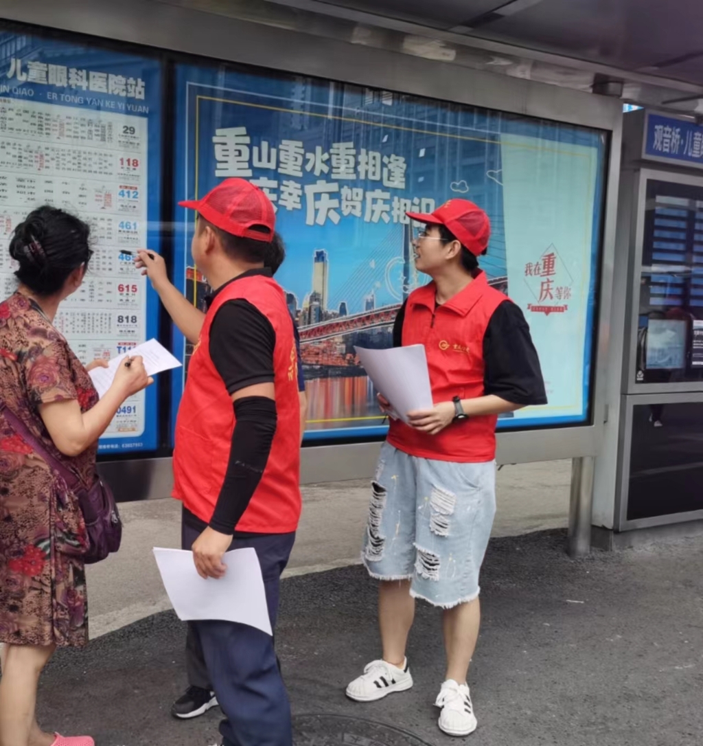 公交志愿者在站台向乘客征询出行意见建议。受访者供图