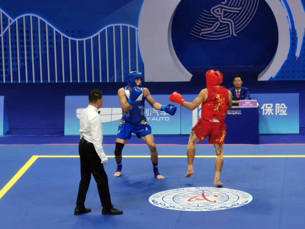 在武术散打70公斤级的比赛中，何烽（蓝方）战胜越南选手阮文才（红方），顺利晋级1/4决赛。重庆市体育局供图