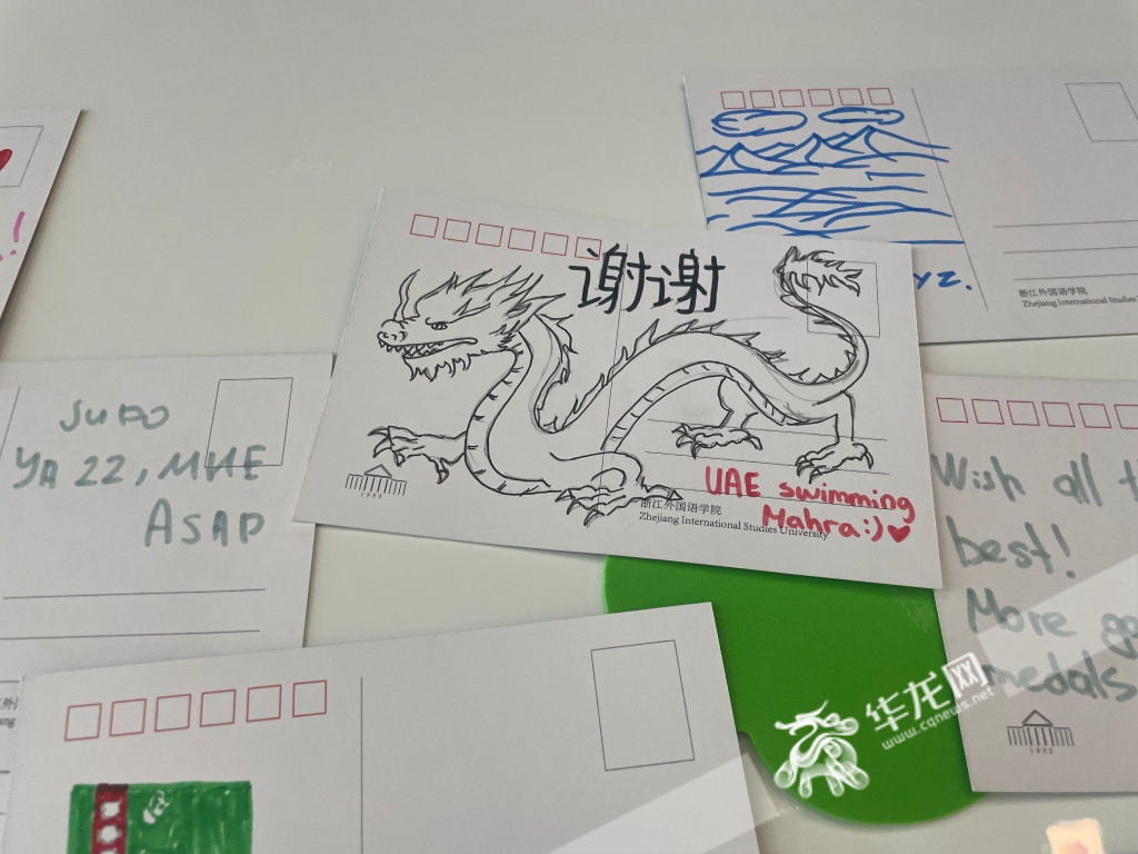 Mahra from the UAE Swimming Team draws a dragon and writes down "Thank you" in Chinese.