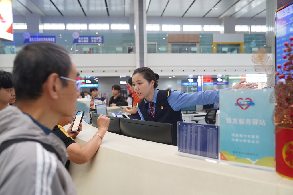 重庆北站“马廉服务台”工作人员引导旅客前往检票口。通讯员 魏伟 摄 