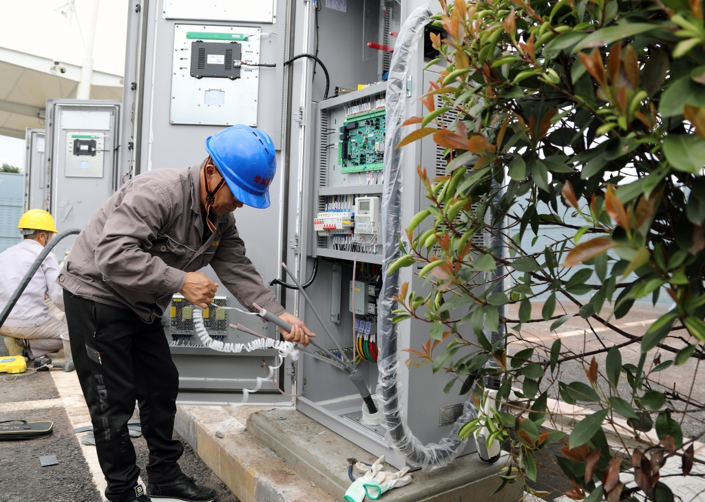 工作人员正加紧检修充电桩，确保国庆正常使用。