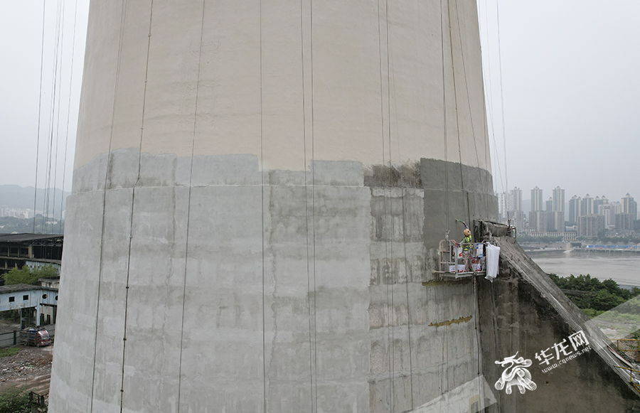 工人对双子烟囱的外墙加固美化。华龙网 首席记者 李文科 摄 