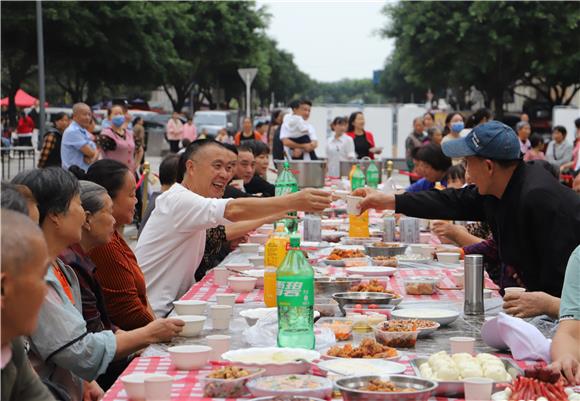 邻里举杯同饮其乐融融。通讯员 杨彦 摄