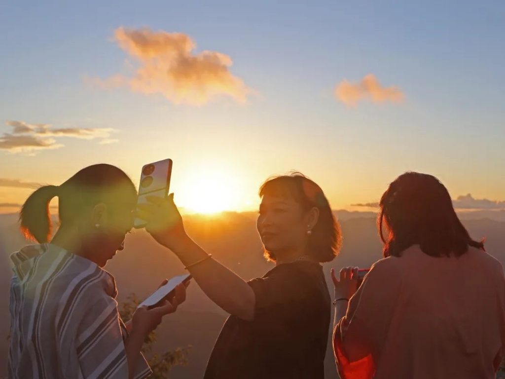 游客在阿依林海景区拍摄夕阳