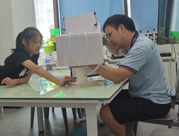 石玥熙在老师的指导下制作模型。受访者供图 华龙网发