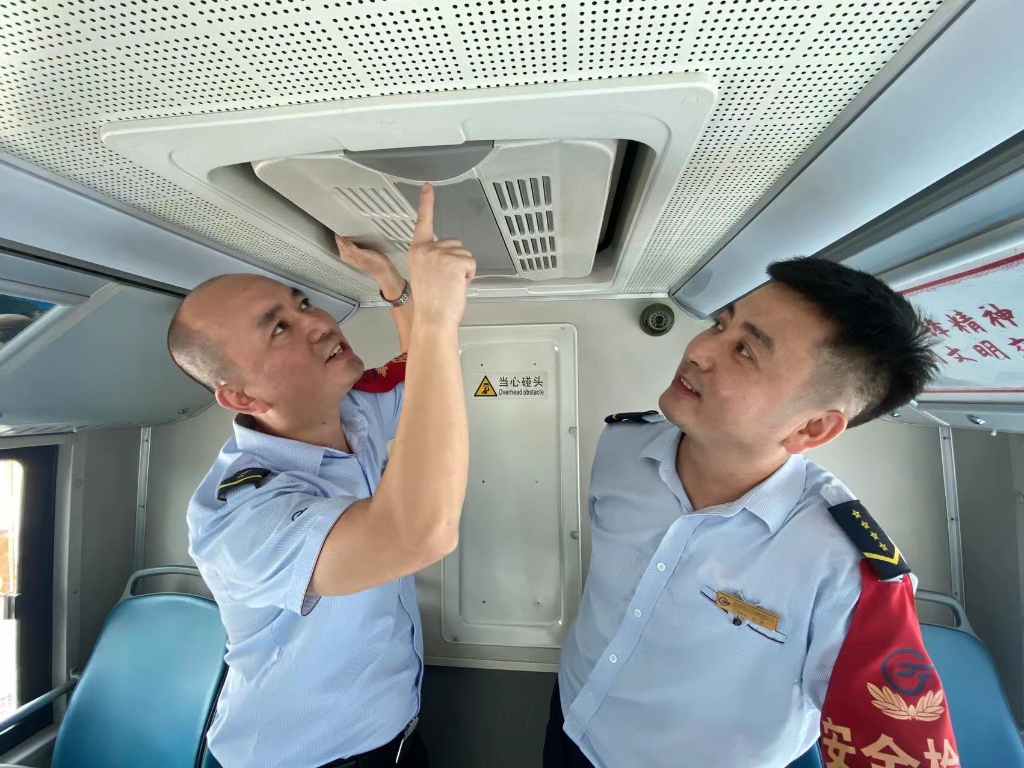 彭曾（右）和师傅禹玉松在车上交流业务。重庆南部公交供图