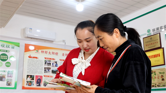 刘春梅帮助村民查阅书籍。江津区委宣传部供图 华龙网发
