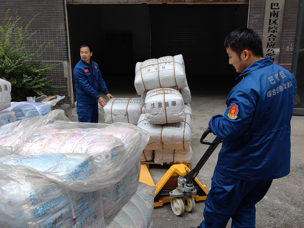 应急队员将物资仓库的救灾棉被、棉衣分发给辖区部分受灾镇街。重庆市应急管理局供图