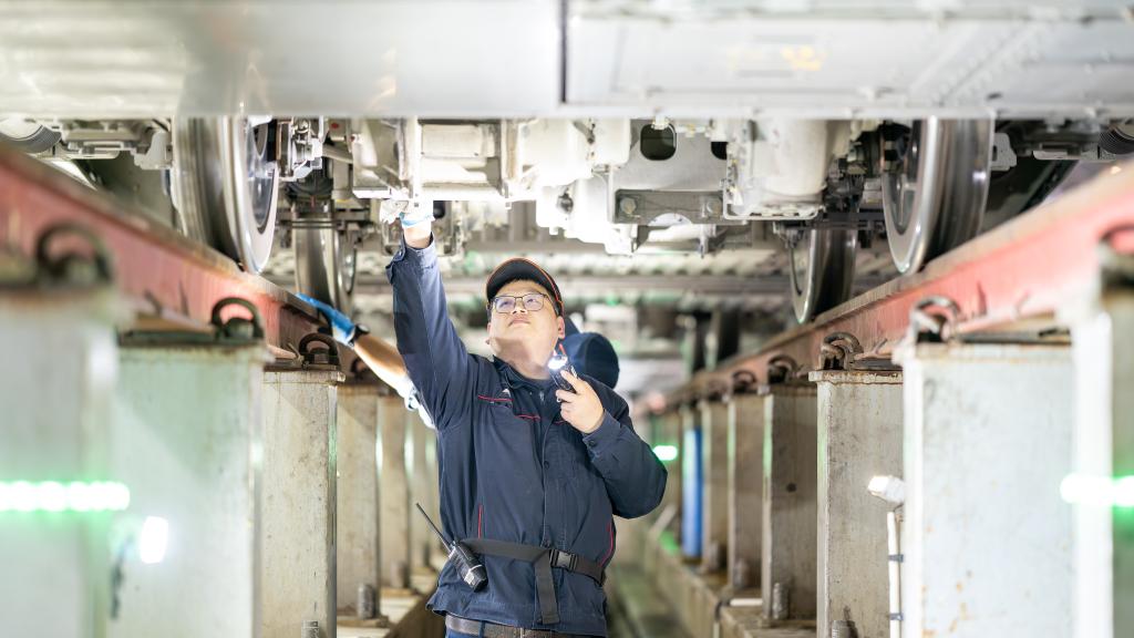 重庆车辆段重庆西动车运用车间班组职工在对动车组轮对、制动装置进行检修。