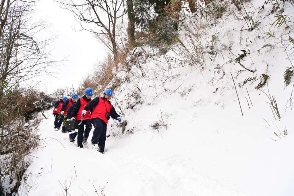 电力员工在雪地里缓慢前行。通讯员 庞涛丹 摄