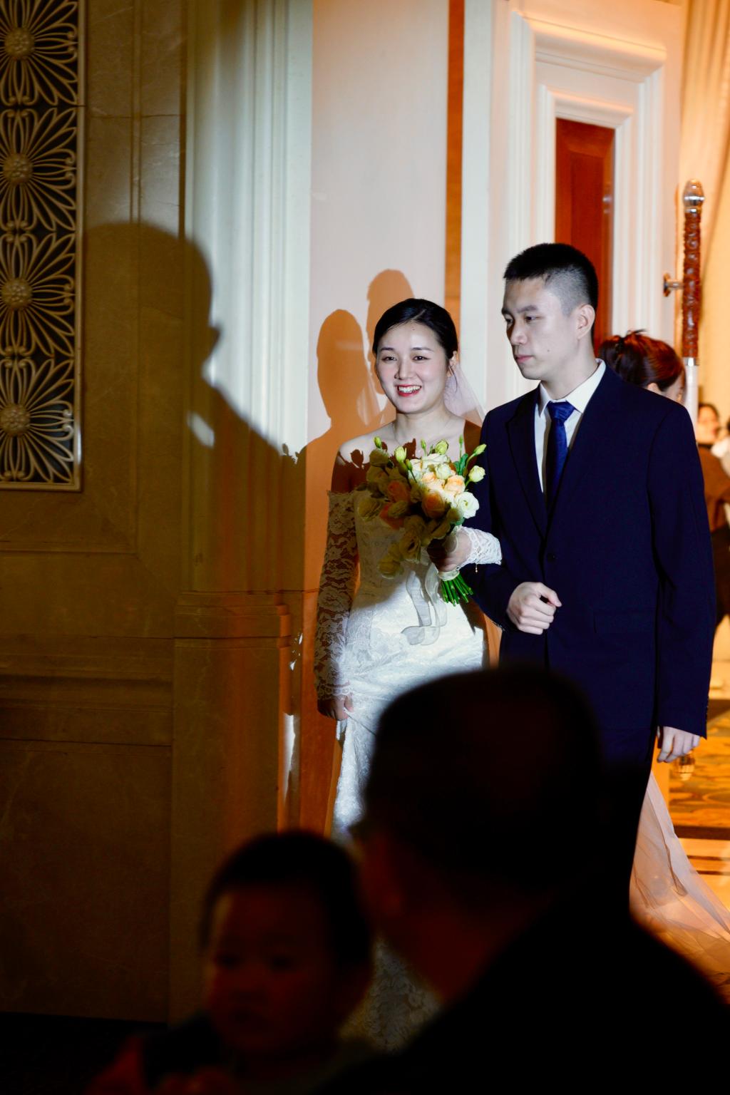 图2 婚礼现场，张榕挽着丈夫的手入场。受访者供图