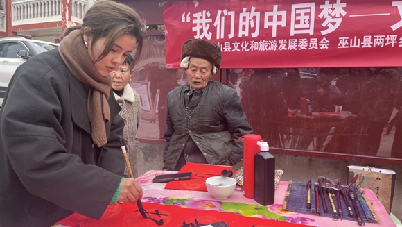 巫山县“我们的中国梦”文化进万家活动现场，巫山县图书馆联合书法家们为村民写春联、赠“福”字。受访者供图