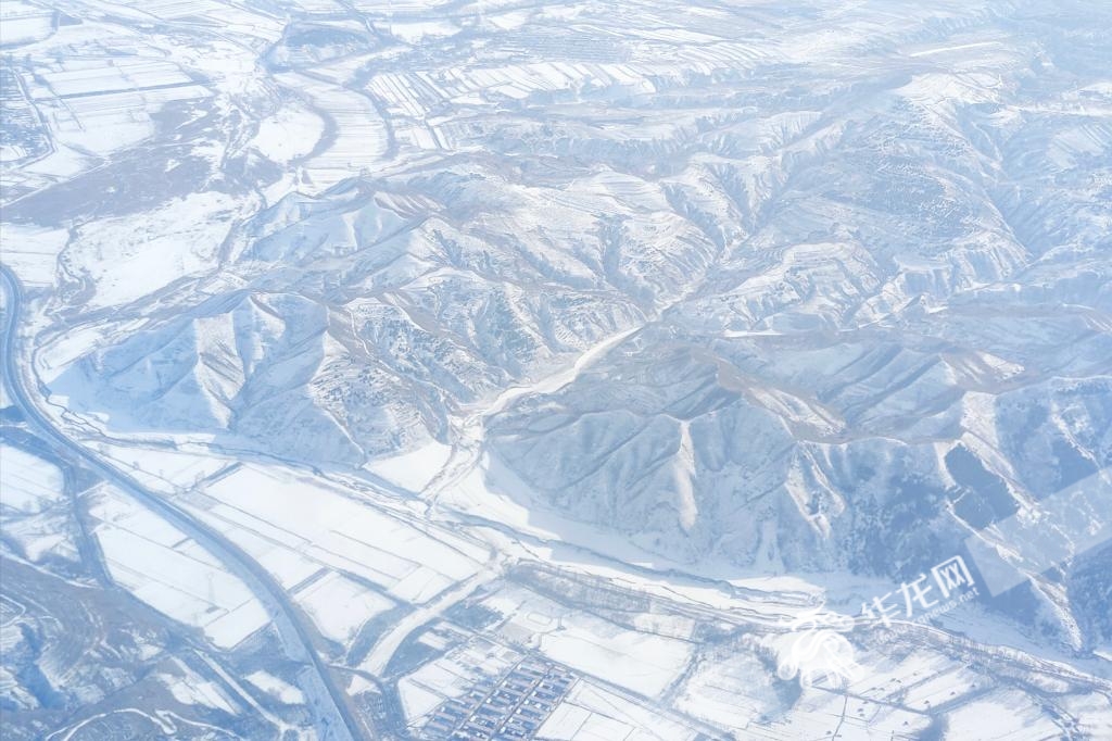 从重庆去往内蒙古呼和浩特的飞机上，俯瞰白雪皑皑的山川大地。华龙网特派记者 石涛 摄