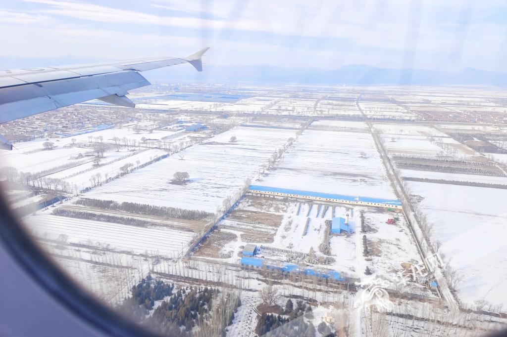 飞机抵达内蒙古呼和浩特白塔机场，地面白雪皑皑。华龙网特派记者 石涛 摄
