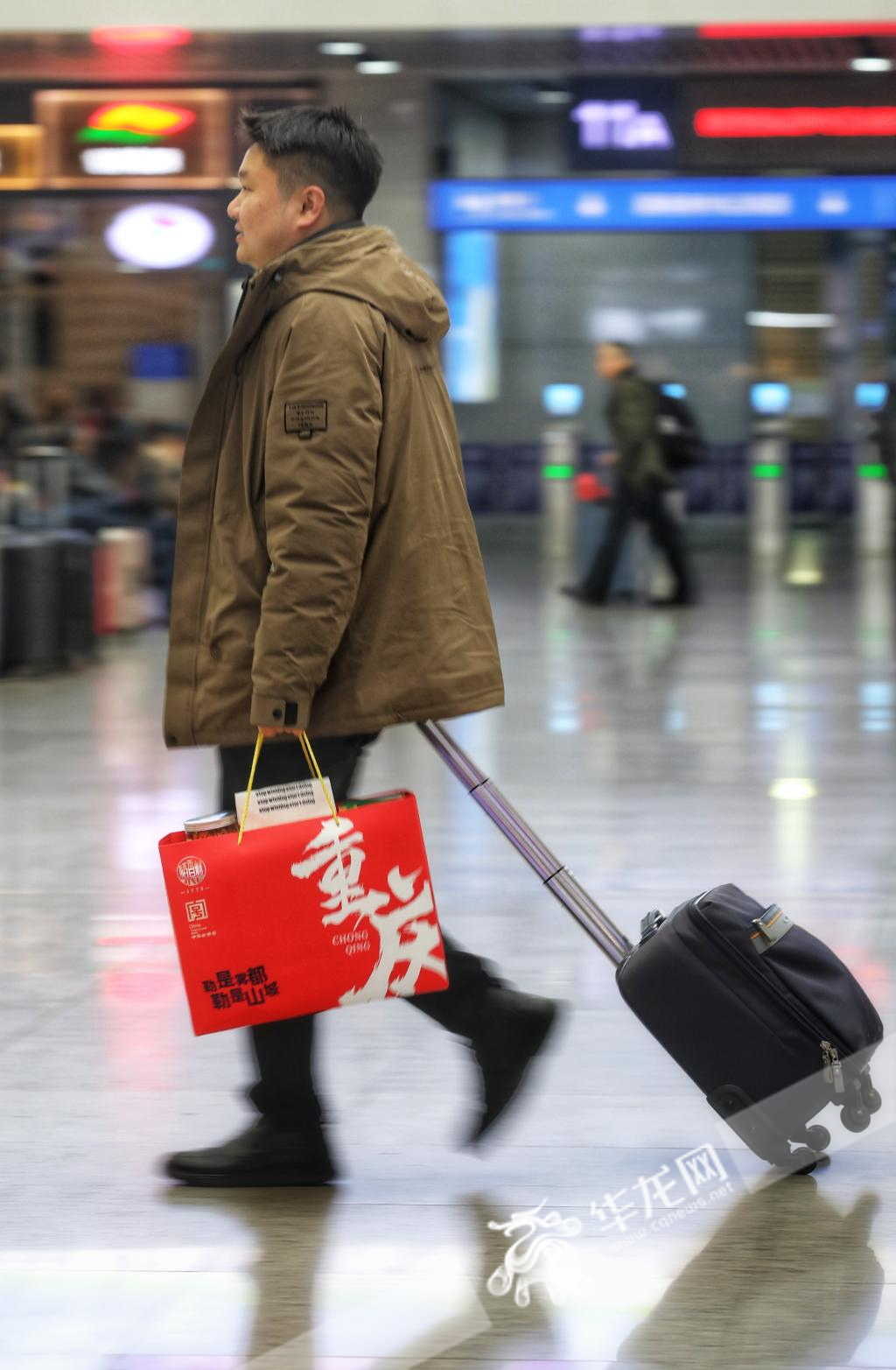 06，这位乘客快步走向检票口，手里提着的红色礼袋是在十八梯买的重庆特产，他要跟家乡的朋友分享重庆味道。