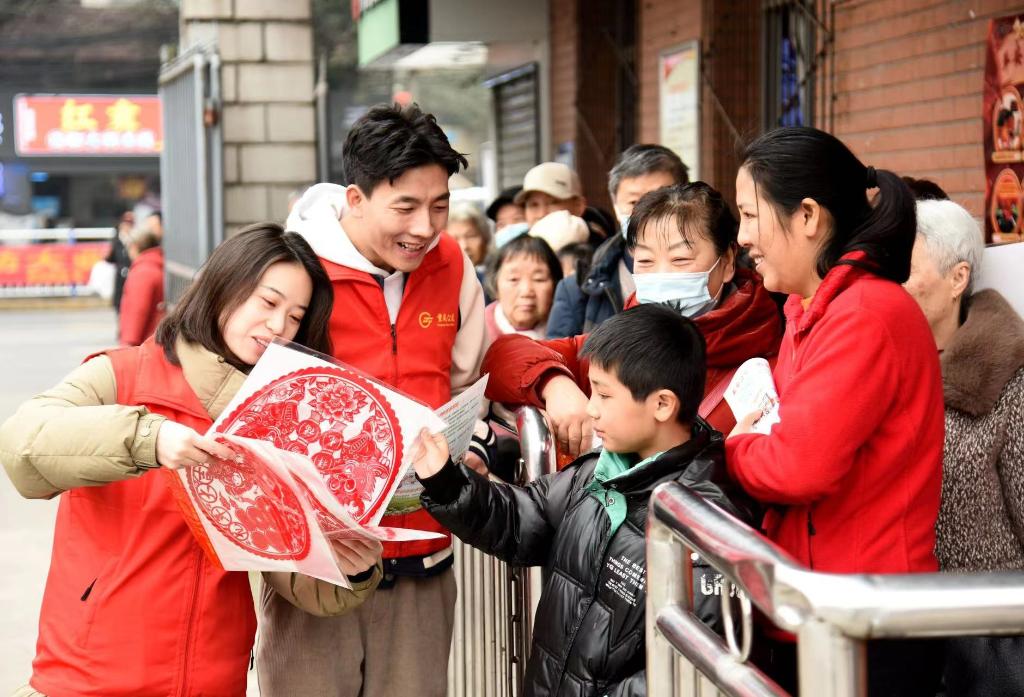 公交志愿者为候车乘客送“福”送春联。重庆北部公交供图