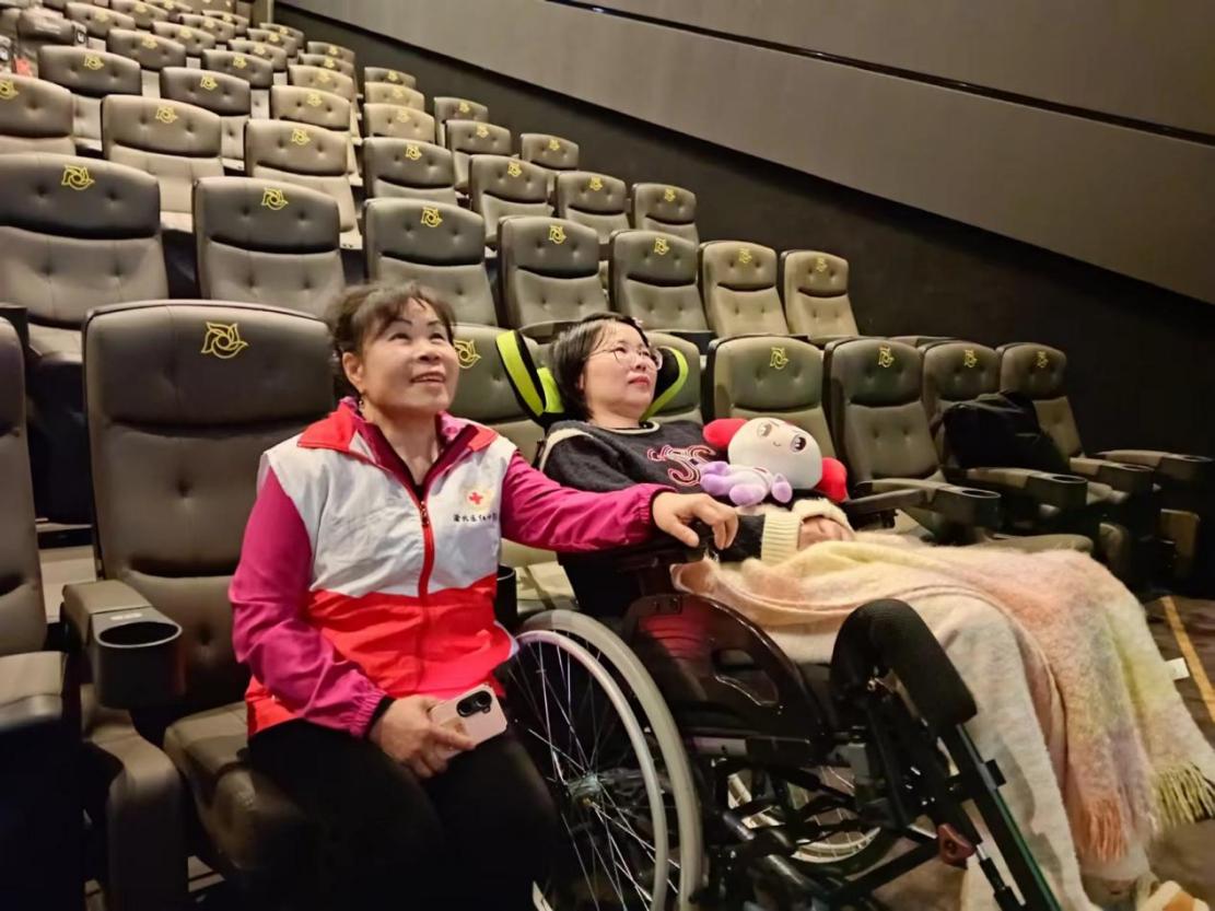 志愿者陈茂秀陪刘洁看电影。受访者供图