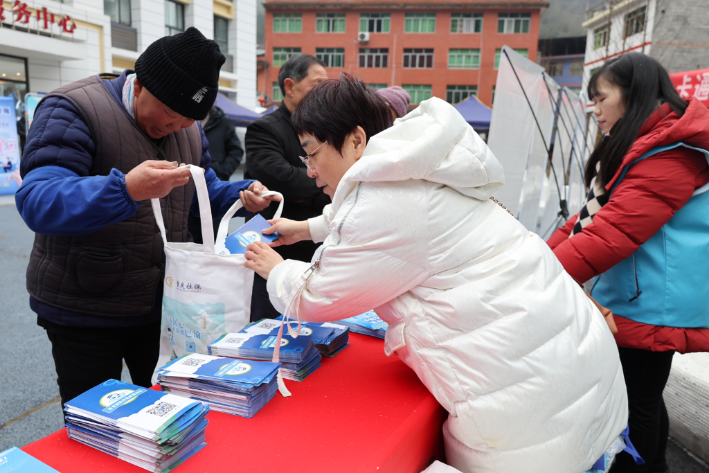 重庆市人力社保部门工作人员正在给群众普及社保知识。重庆市人力社保局 供图