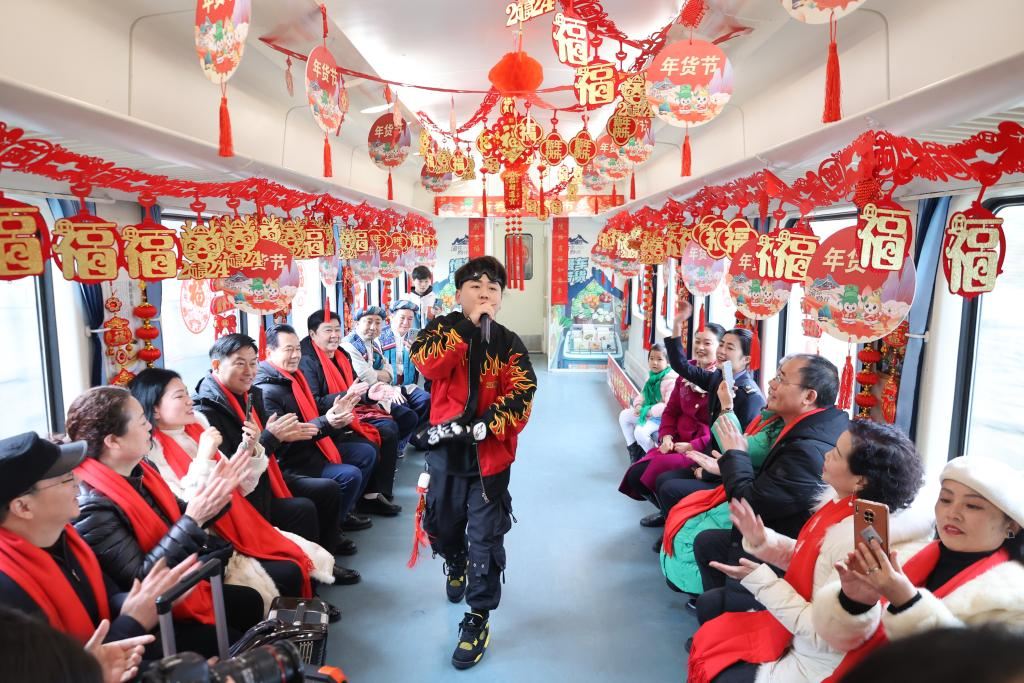 A train carriage decorated with lights and colored hangings including the Spring Festival couplets, Chinese knots and Year of the Dragon themed hangings