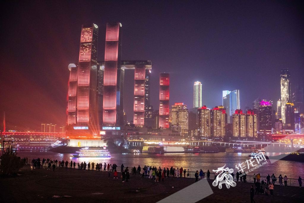 演出结束后，意犹未尽的市民们在江边继续欣赏美丽的重庆除夕夜景。华龙网记者 石涛 摄