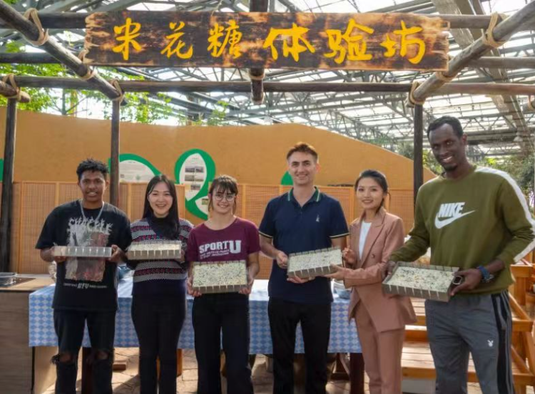 Foreign communication officers were attracted by the techniques of making crunchy rice candy and wine. (Photo provided by the interviewee)