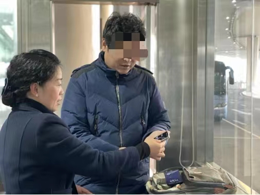 公交工作人员帮乘客（右）找回遗失在车上的手机。重庆两江公交供图