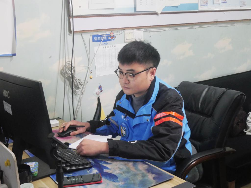陈涛在电脑面前处理配送调度工作。视频截图
