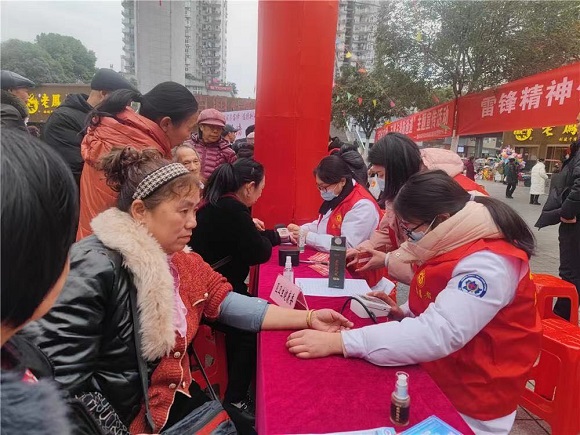 “梁家人”志愿者在给市民测量血压。通讯员 谢清城 摄
