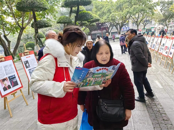 文明志愿者为居民解读《渝北文明八条》口袋书。两路街道办事处供图 华龙网发