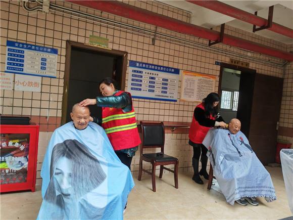 青年爱心志愿者为老人们理发、剃须。通讯员 邹琼 摄