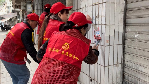 志愿者清除小广告。江北区五里店街道供图 华龙网发