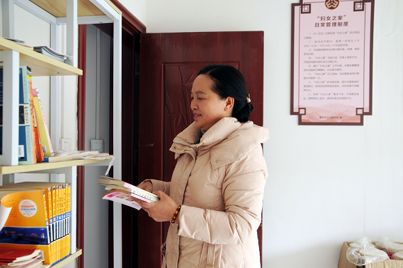 秀山县清溪场街道东林社区妇联主席张雪梅正在整理妇女儿童读物。通讯员 杨帆摄