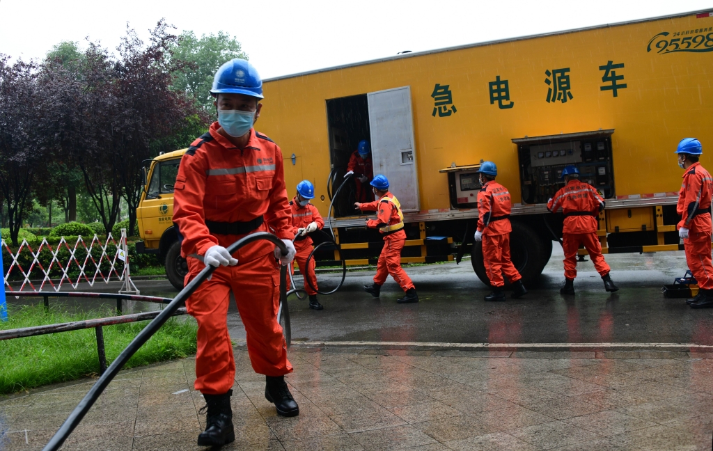 國家電網應急救援人員在江津區中心醫院施放應急發電車電纜進行保電