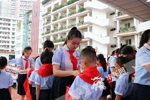 新村实验小学老队员为新队员系上红领巾 陈佳 摄