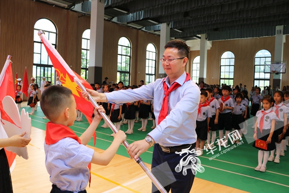 新村教育集团校长向新队员代表授旗 陈佳 摄