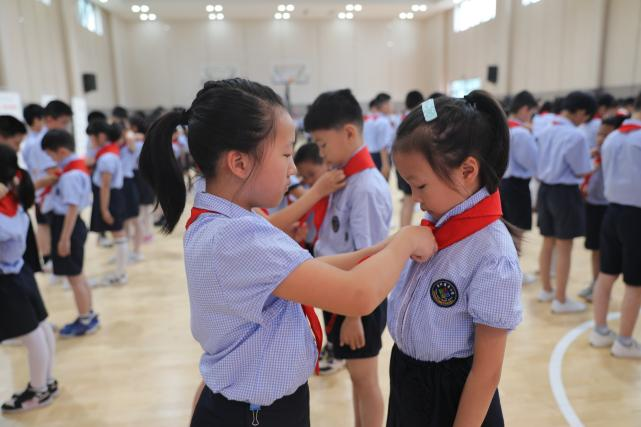 新村国奥小学老队员为新队员系上红领巾 学校供图 华龙网 发