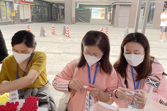 社区入户核酸检测志愿者正在工作中（右二为卓丽霞和女儿） 受访者供图 华龙网发