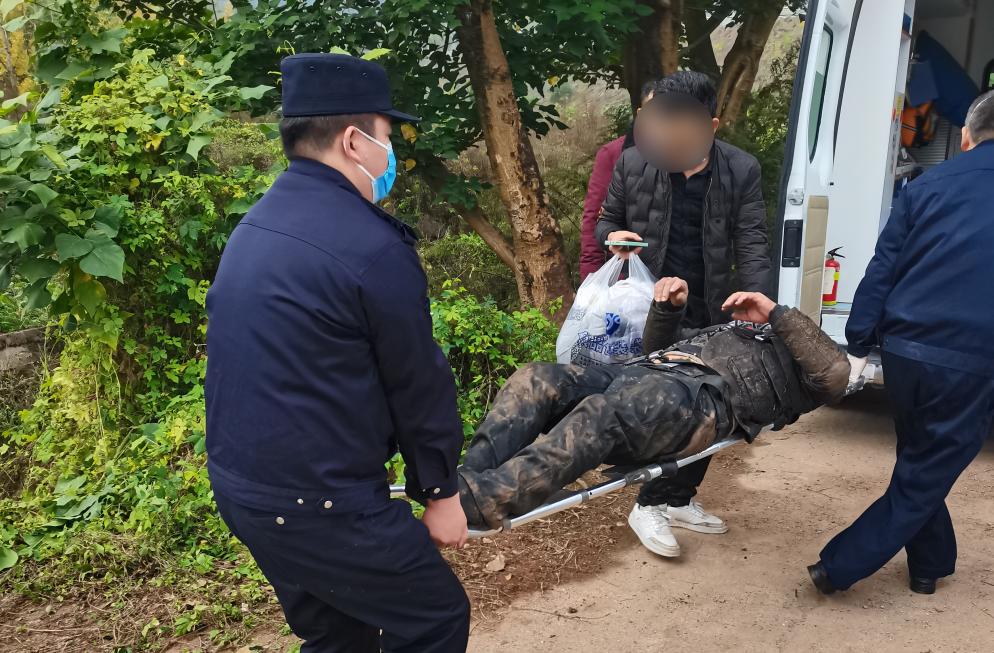 民警将老人抬上救护车