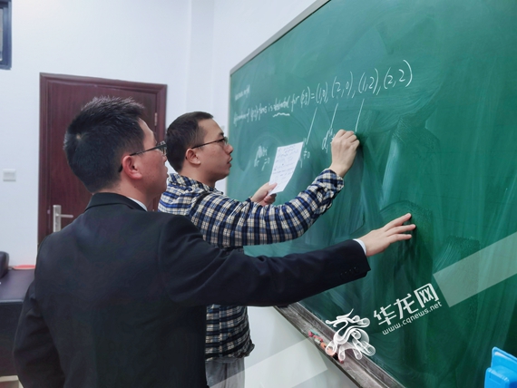 万学远正与同事交流学术问题 许义丽 摄